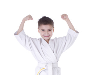 Young boy fighter in kimono with hand up isolated on white background